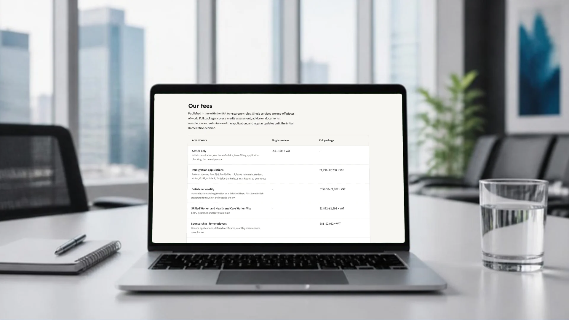 A laptop on an office meeting table showing the Compass fees page, with published fee ranges for advice, immigration applications, British nationality, work visas and sponsorship