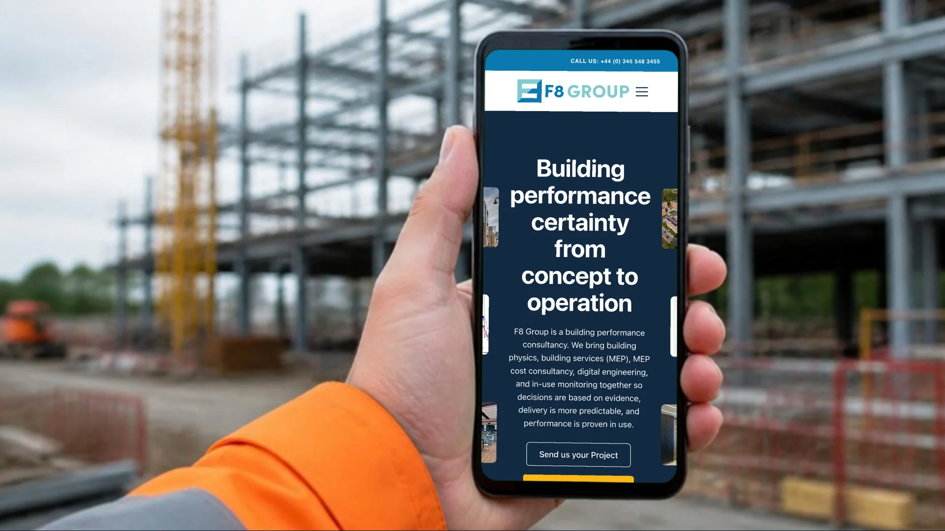 A hand in a hi-vis sleeve holding a phone on a building site, showing the F8 Group homepage and its Send us your project button